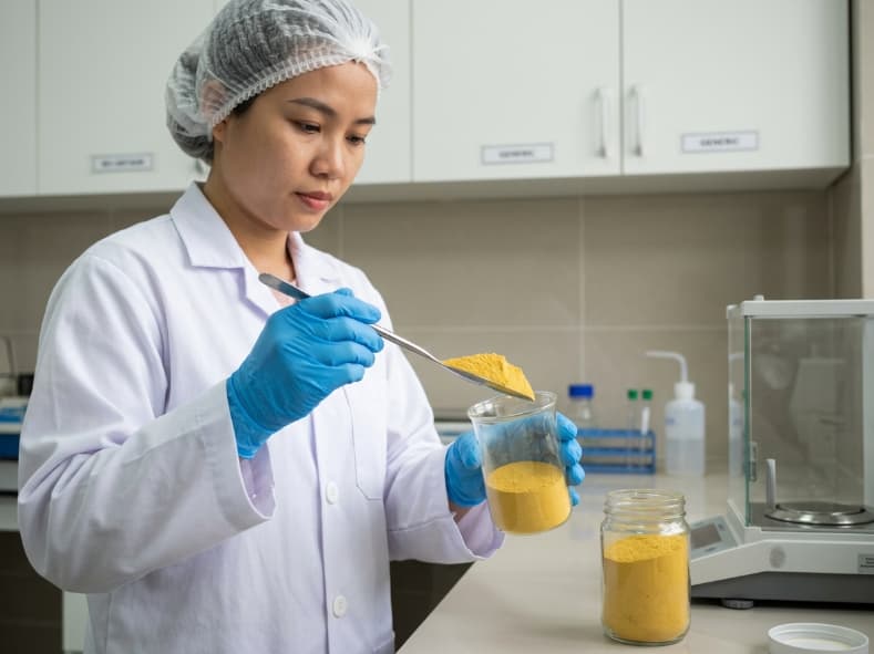 laboratory technician checking the particle texture of seedless freeze dried passion fruit powder