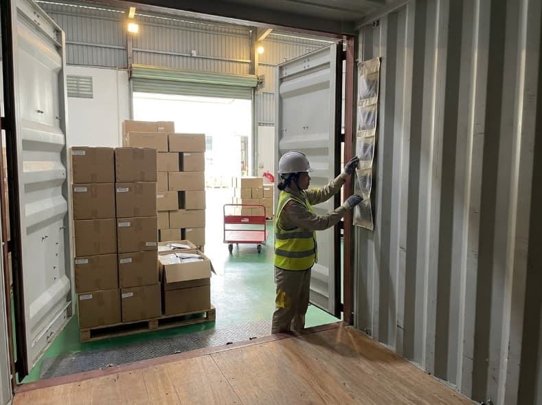 logistics inspector checking container desiccant and dry floor before loading freeze dried fruit cartons