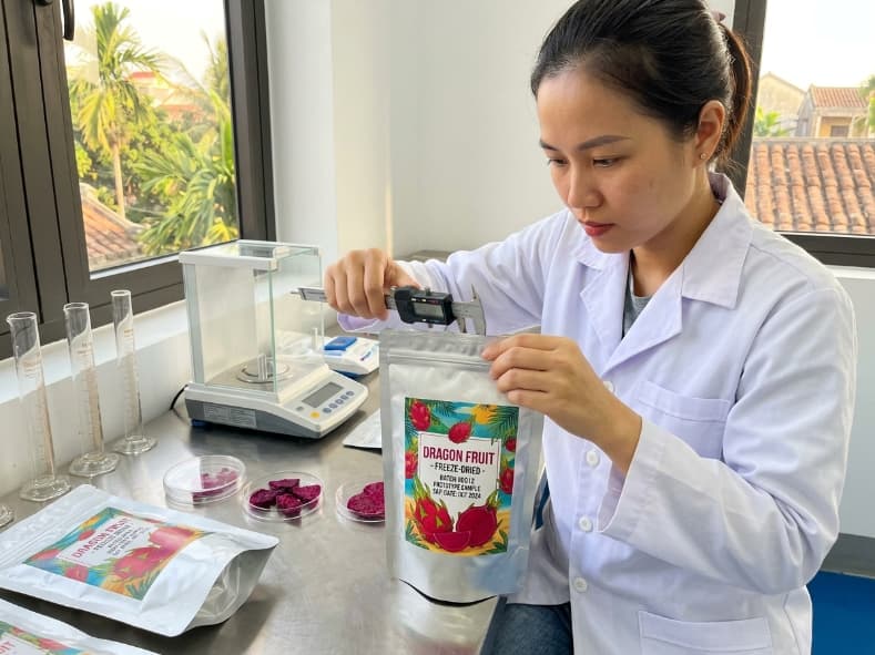 Private Label Freeze-Dried Dragon Fruit: From Product Brief to Bulk Release qa technician measuring seal width on a private label freeze dried dragon fruit sample pouch in a vietnam laboratory
